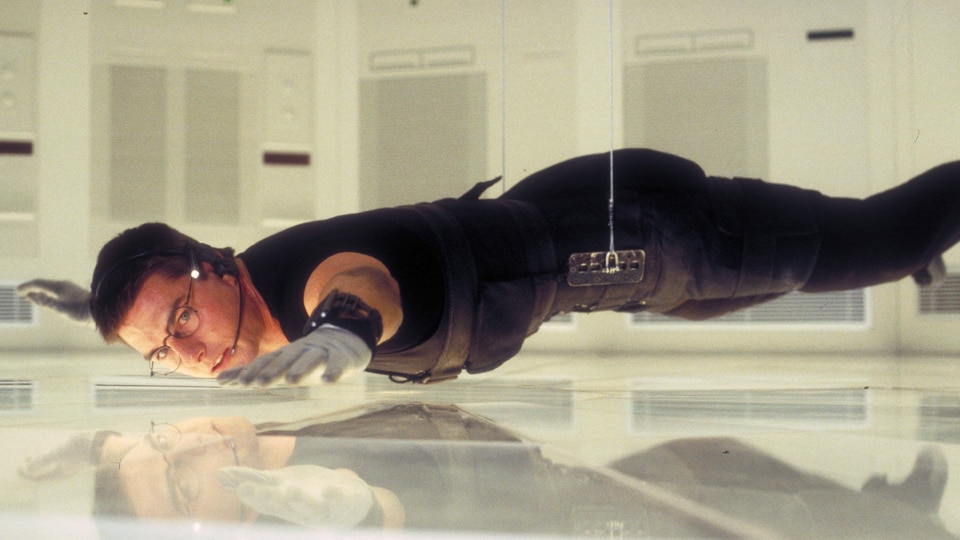 Ethan Hunt (Tom Cruise) hovers over the floor during a spy mission in Mission: Impossible (1996).