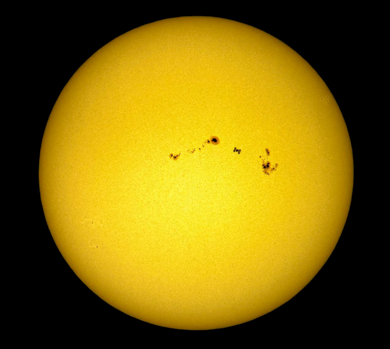 ISS transiting the Sun between two huge sunspot groups. Credit: Dani Caxete