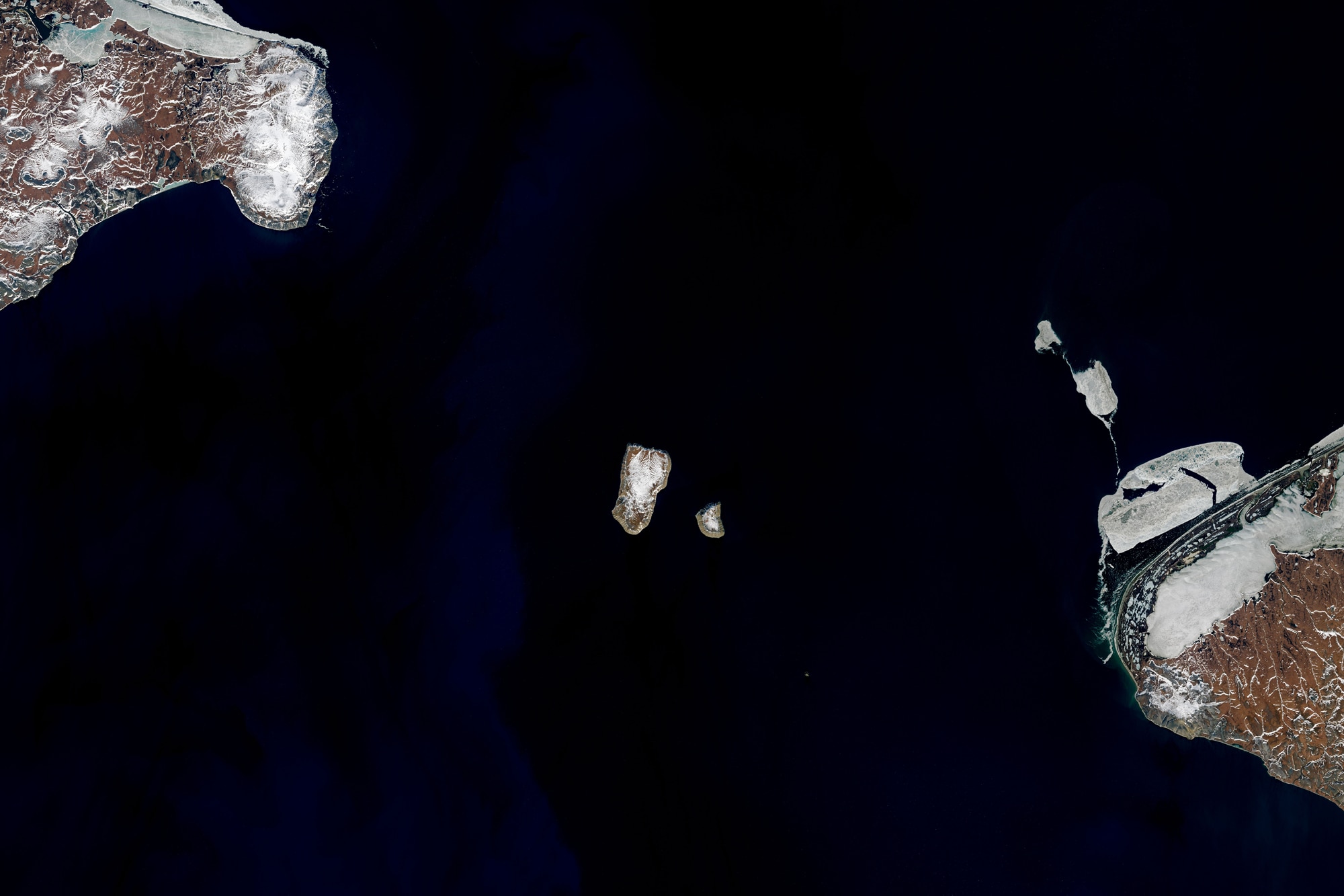 Landsat 8 image of the Diomedes islands from space. On the right is Alaska, and the left Russia. Credit: NASA Earth Observatory images by Joshua Stevens, using Landsat data from the U.S. Geological Survey