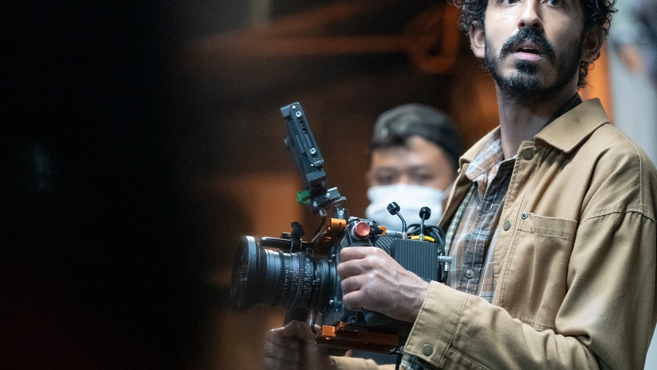 Dev Patel holds a camera on the set of his film Monkey Man (2024).