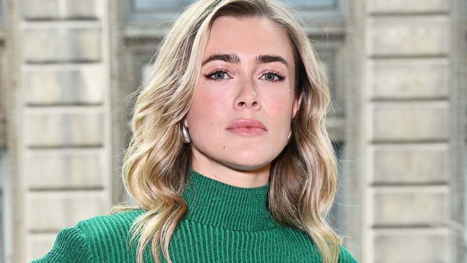 Melissa Roxburgh attends a fashion show in a green sweater