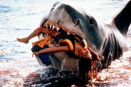 A shark with a bloodied woman in its mouth from Jaws (1974)