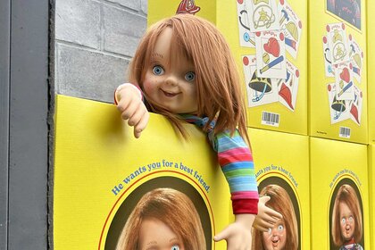 Chucky hanging over a stack of boxes at the Chucky Activation during San Diego Comic-Con 2023