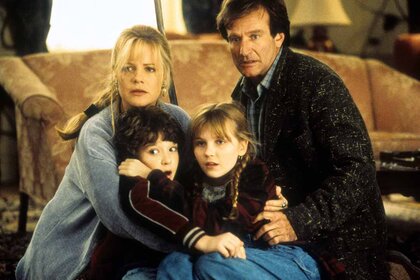 Bonnie Hunt, Bradley Pierce, Kirsten Dunst and Robin Williams hold each other in Jumanji (1995).