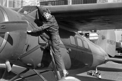 Amelia Earhart going into an airplane
