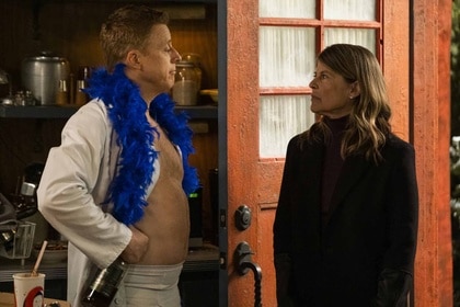 Harry Vanderspeigle (Alan Tudyk) looks at General Eleanor Wright (Linda Hamilton) with a blue boa and open shirt in Resident Alien episode 306.