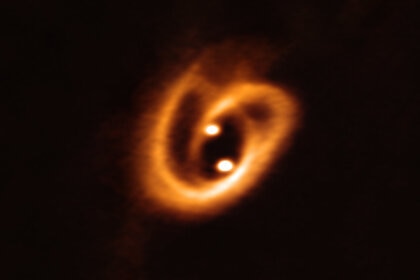 The two stars of the binary system [BHB2007] 11 are in the process of forming, drawing material from the disk surrounding both via a pair of filaments, wound up due to the motion of the stars around each other. Credit: ALMA (ESO/NAOJ/NRAO), Alves et al.