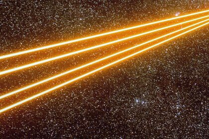 Four powerful lasers fire from the Very Large Telescope to create artificial guide stars in the sky near the Carina Nebula. Credit: ESO/G. Hüdepohl