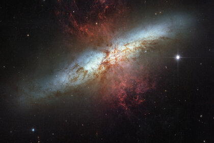 The starburst galaxy M82, with red tendrils of gas and dust being expelled by stars in its center. Credit: NASA, ESA and the Hubble Heritage Team (STScI/AURA). Acknowledgment: J. Gallagher (University of Wisconsin), M. Mountain (STScI) and P. Puxley (NSF)