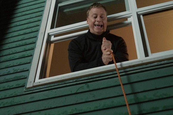 Harry Vanderspeigle pulls on a rope out of a window in Resident Alien Episode 302.
