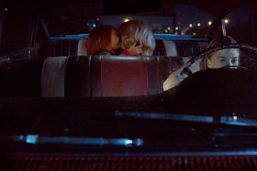 Chucky and Tiffany make out in the backseat of a car as Caroline Cross drives on Chucky Episode 308.