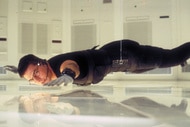 Ethan Hunt (Tom Cruise) hovers over the floor during a spy mission in Mission: Impossible (1996).