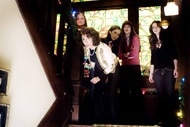 The cast of Black Christmas (2006) peers from a staircase.