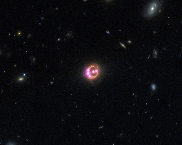 The quasar RX J1131-1231 appears as a series of bright dots on a ring around the fuzzy elliptical galaxy in the center due to gravtiational lensing. This is a Hubbel image (red, green, and blue) combined with Chandra which sees X-rays (displayed as pink).