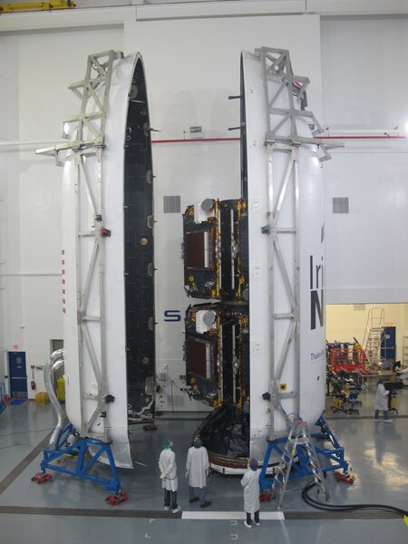 Ten Iridium NEXT satellites are mounted inside the SpaceX Falcon 9 payload fairing, ready to be places on top of the rocket stack. Note the people at the bottom for scale. Credit: Iridium