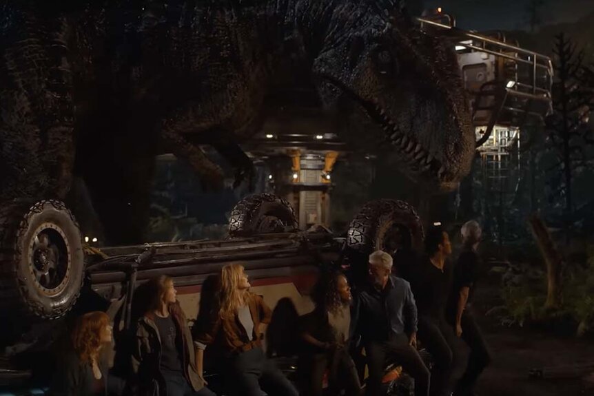 People hide behind a car from a Giganotosaurus in Jurassic World Dominion (2022)