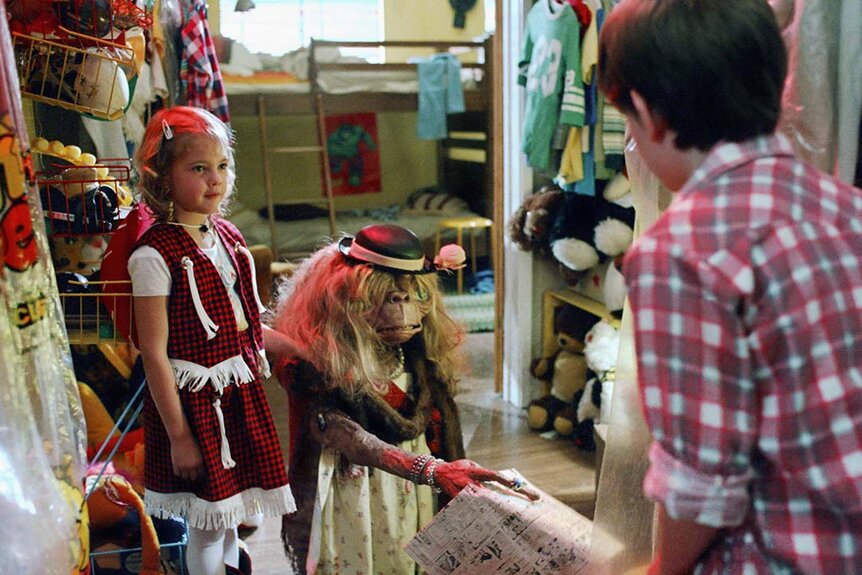 (L-R) Gertie (Drew Barrymore) dresses up E.T. as Elliott (Henry Thomas) appears in E.T. (1982)