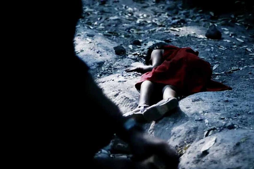 A dead body in a red dress appears on the ground in Monsters (2010).