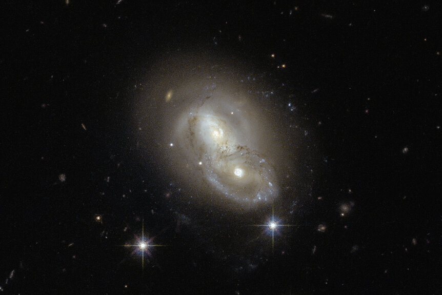 A closer look at IRAS 06076-2139. The southern galaxy (lower right) has suffered at least one collision in the past; note the ring structure around the core, evidence a smaller galaxy plowed through it. Credit: ESA/Hubble &amp; NASA