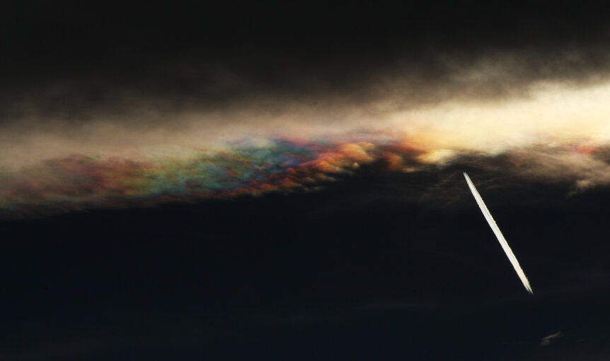 Contrast-enhanced view of iridescent lenticular clouds over Boulder, Colorado. Note the airplane. Credit: Phil Plait