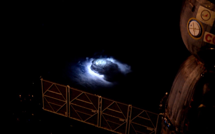 Storm cloud lit from within by lightning, seen from space.