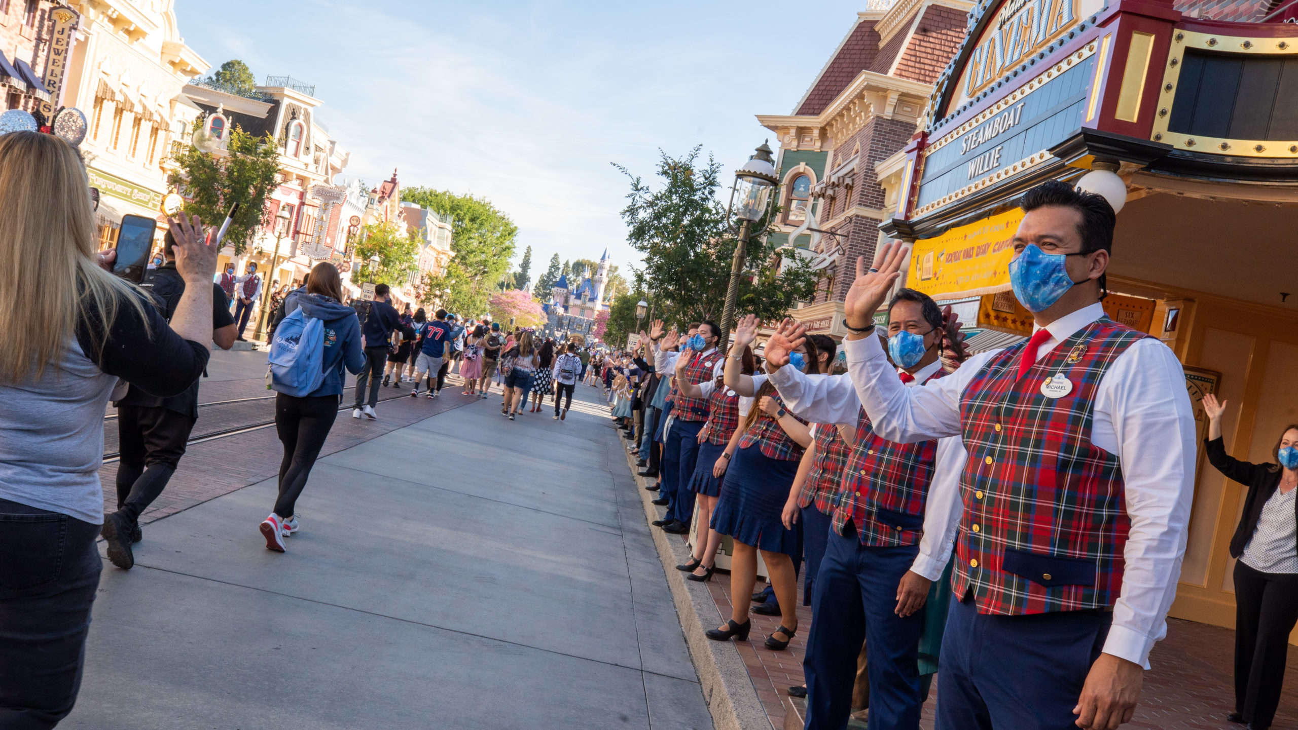 Disney "cast members" welcome back guests on Disneyland Resort's opening day