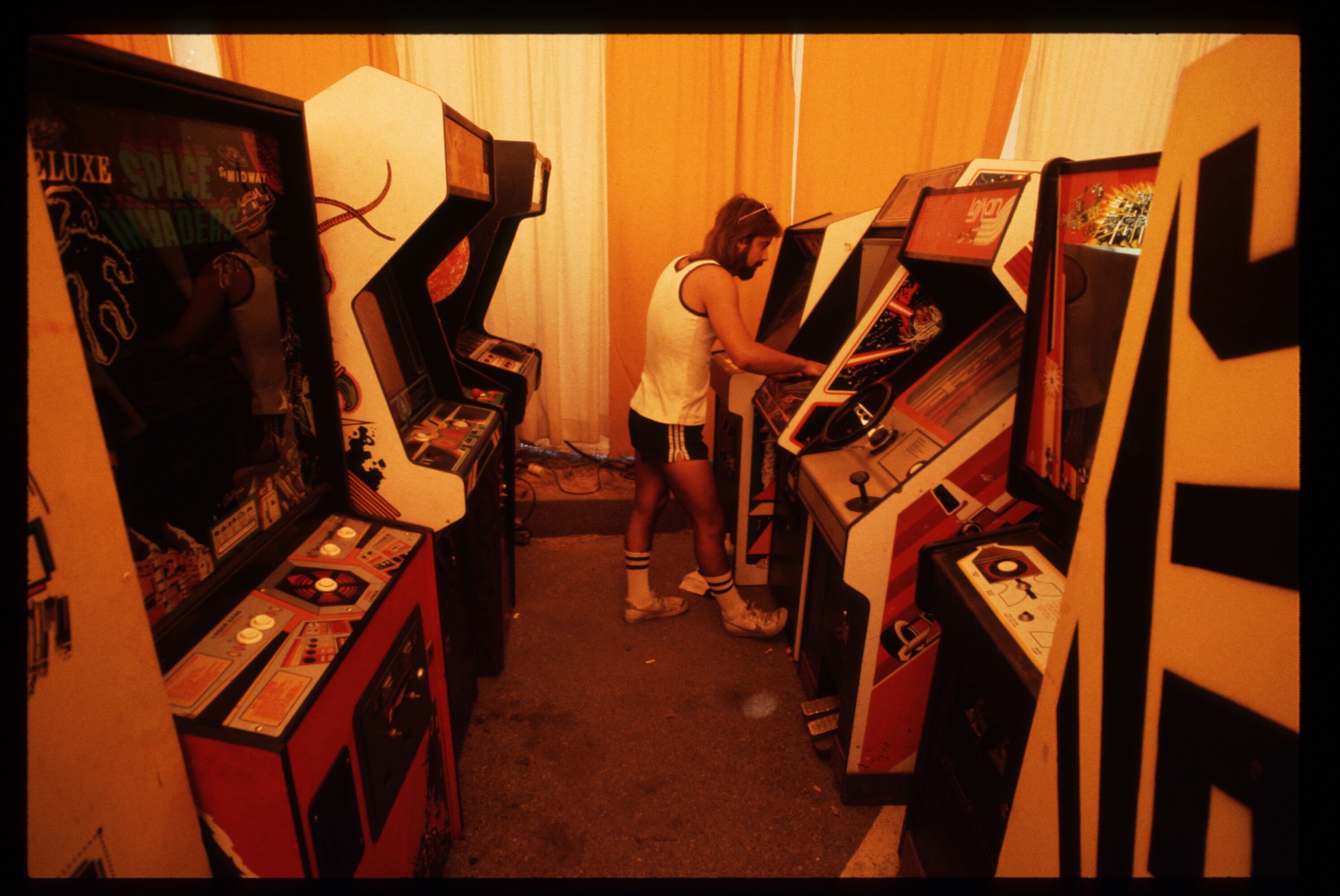 Man playing video game at 1980s arcade