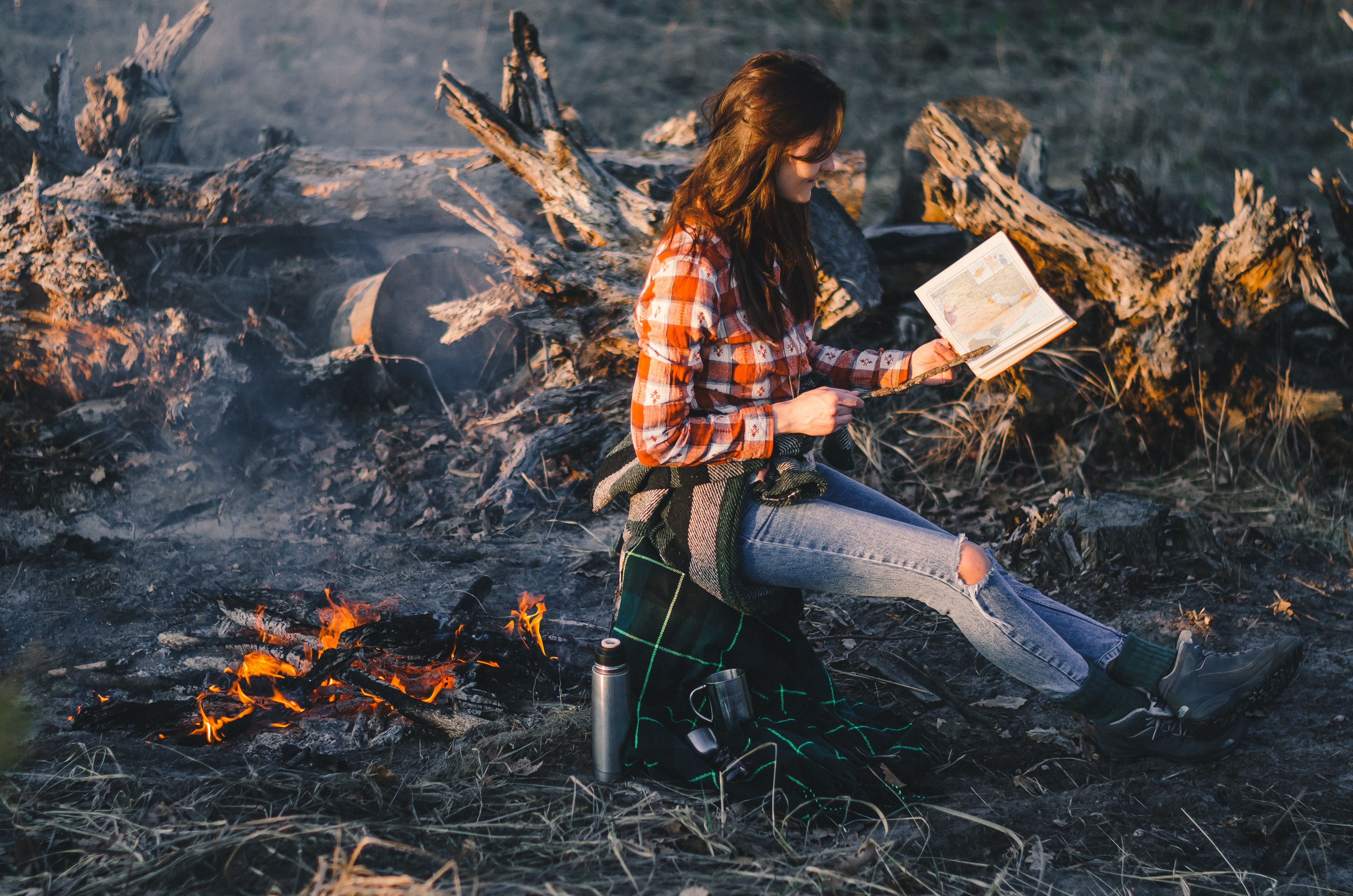 woman-reading-outdoors-fire