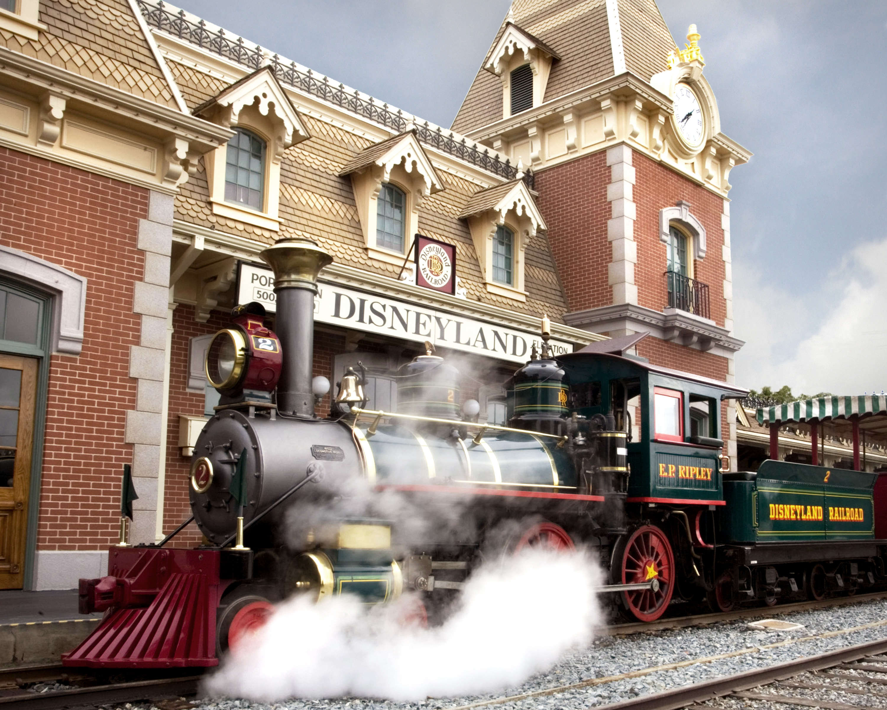 Disneyland steam train in front of a Disneyland sign
