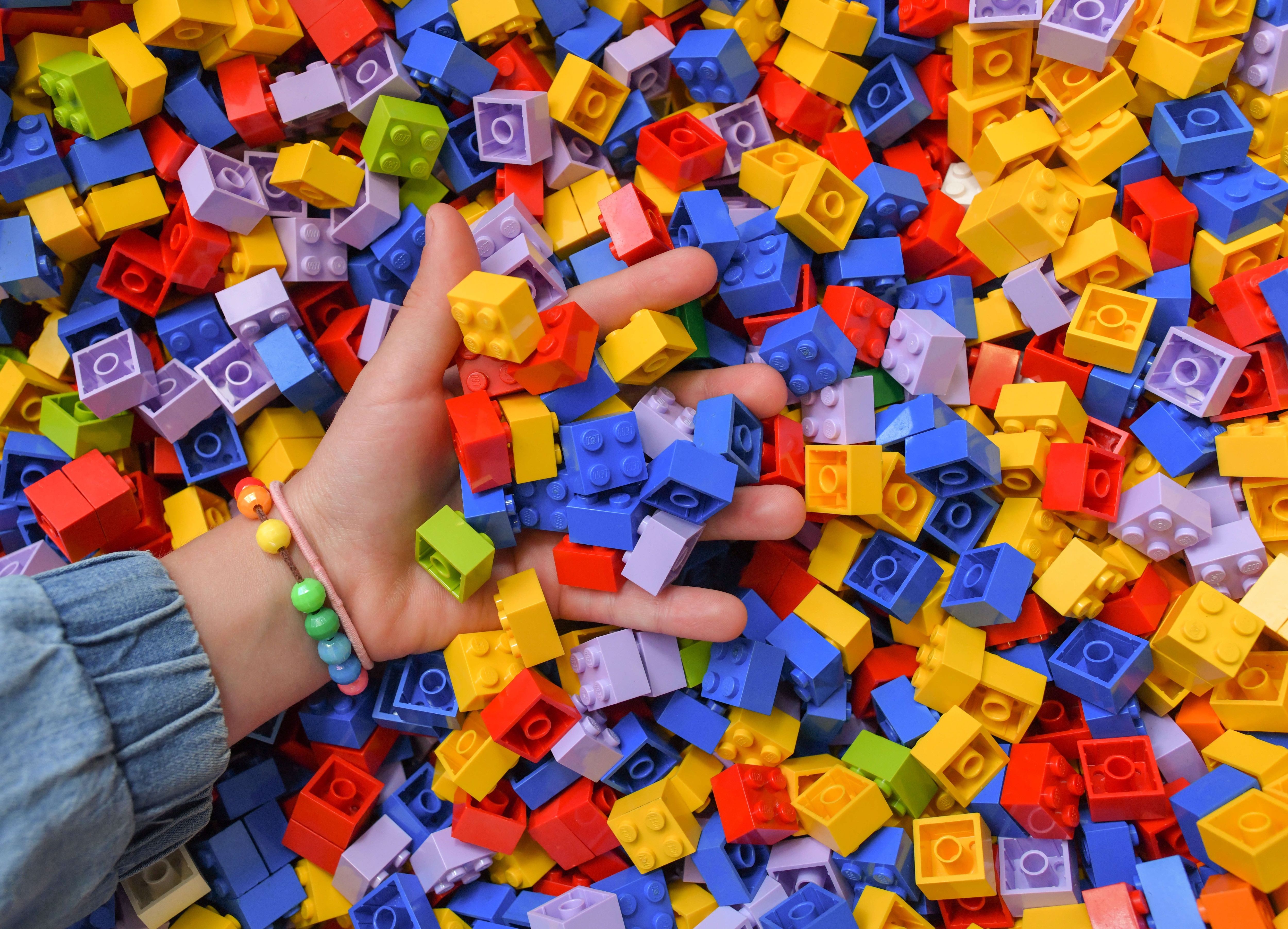 LEGO pile with hand Getty