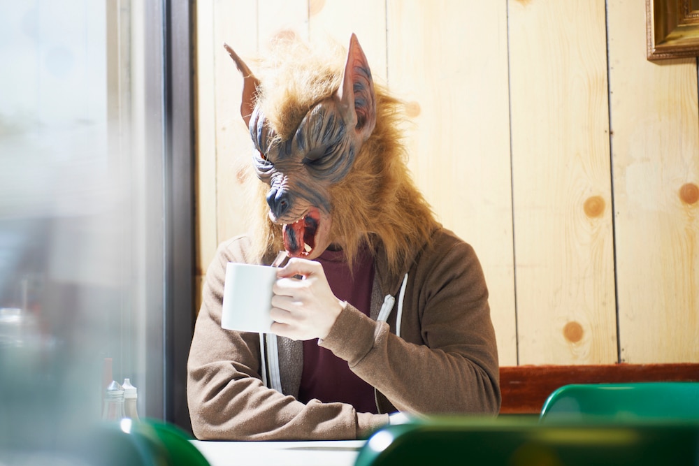 Werewolf with mug in cafe