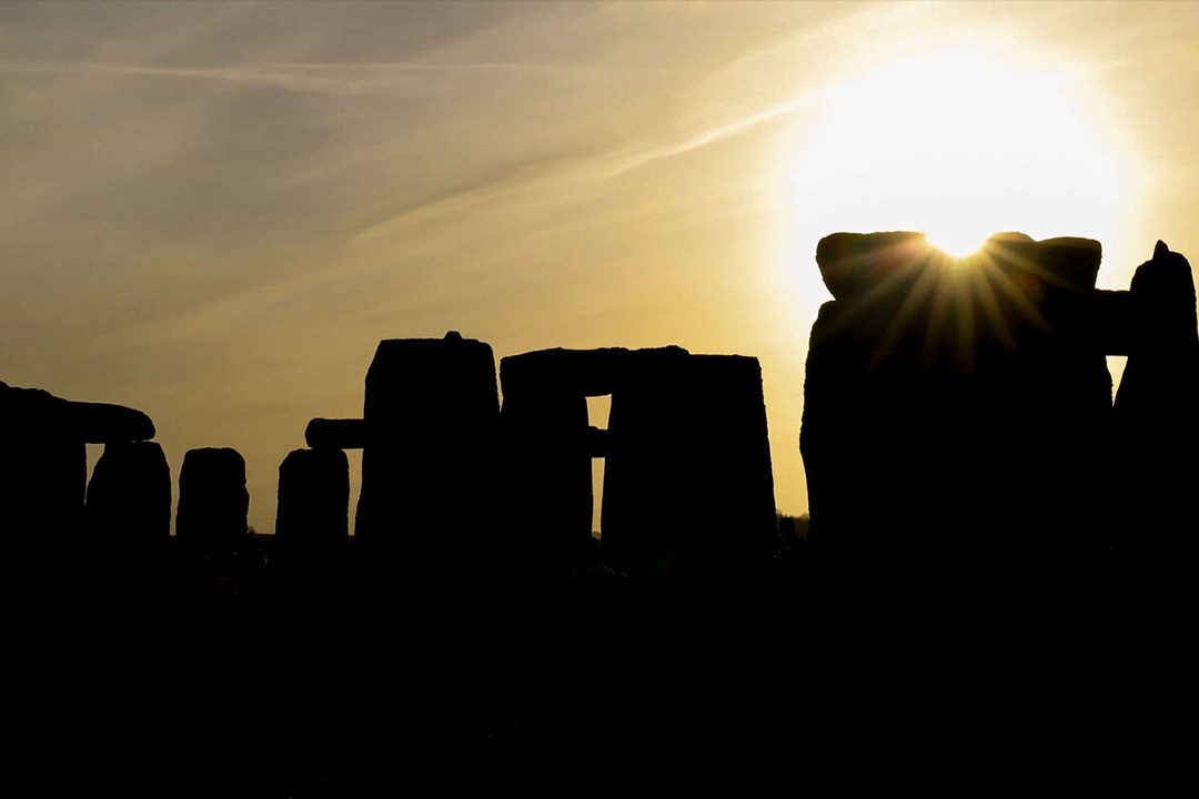 The sun peaking out behind Stonehenge