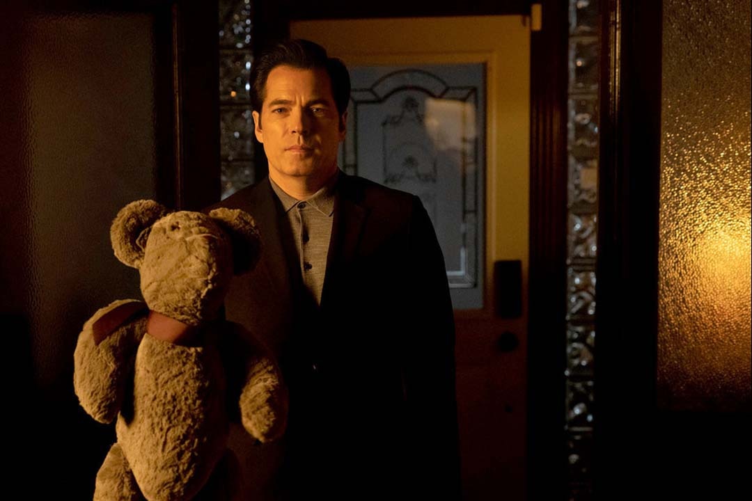 Luke Roman (Tim Rozon) holds a teddy bear in SurrealEstate 201 "Trust the Process".