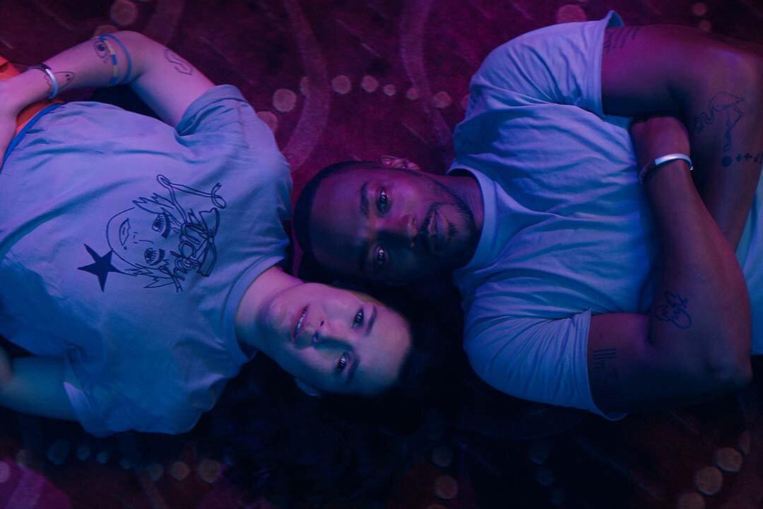 Adam (Anthony Mackie) and Jane (Zoë Chao) lay with their heads looking up side by side and bodies pointed away from each other in If You Were The Last (2023).