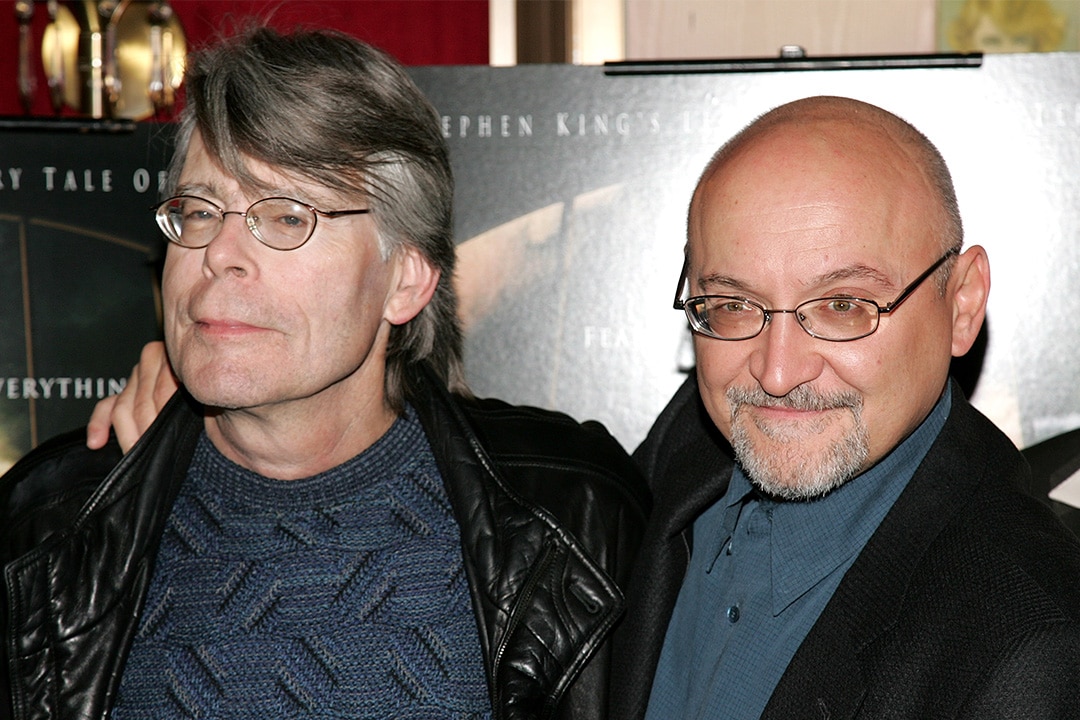 Writer Stephen King and writer/director Frank Darabont smile and embrace at the premiere of The Mist.