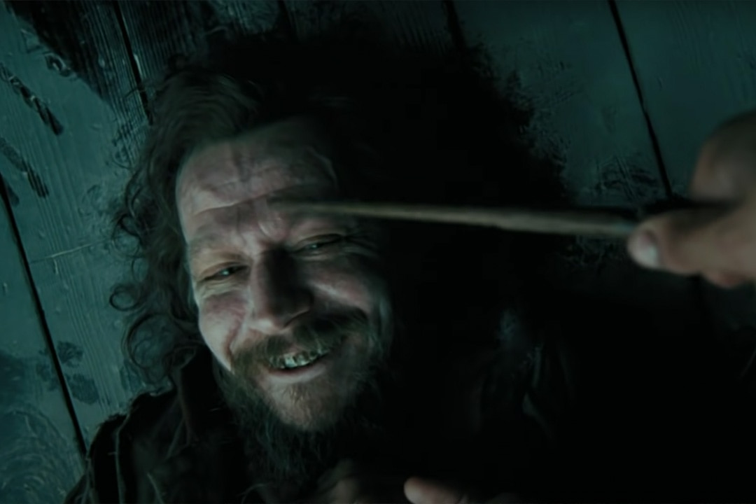 Sirius Black (Gary Oldman) smiles on the ground as a wand is pointed to his forehead in Harry Potter and the Prisoner of Azkaban (2004).