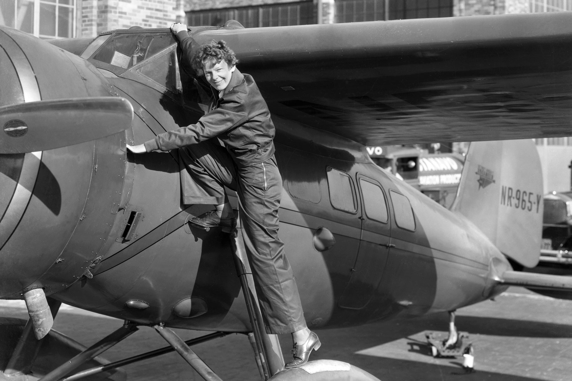 Amelia Earhart going into an airplane