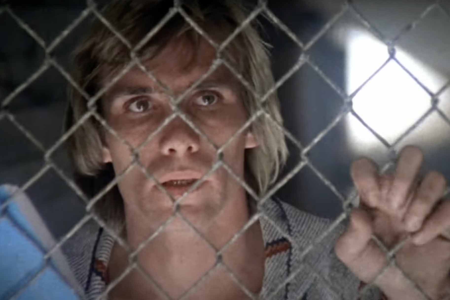 Cameron (Steve Railsback) grips a fence in The Stunt Man (1980).