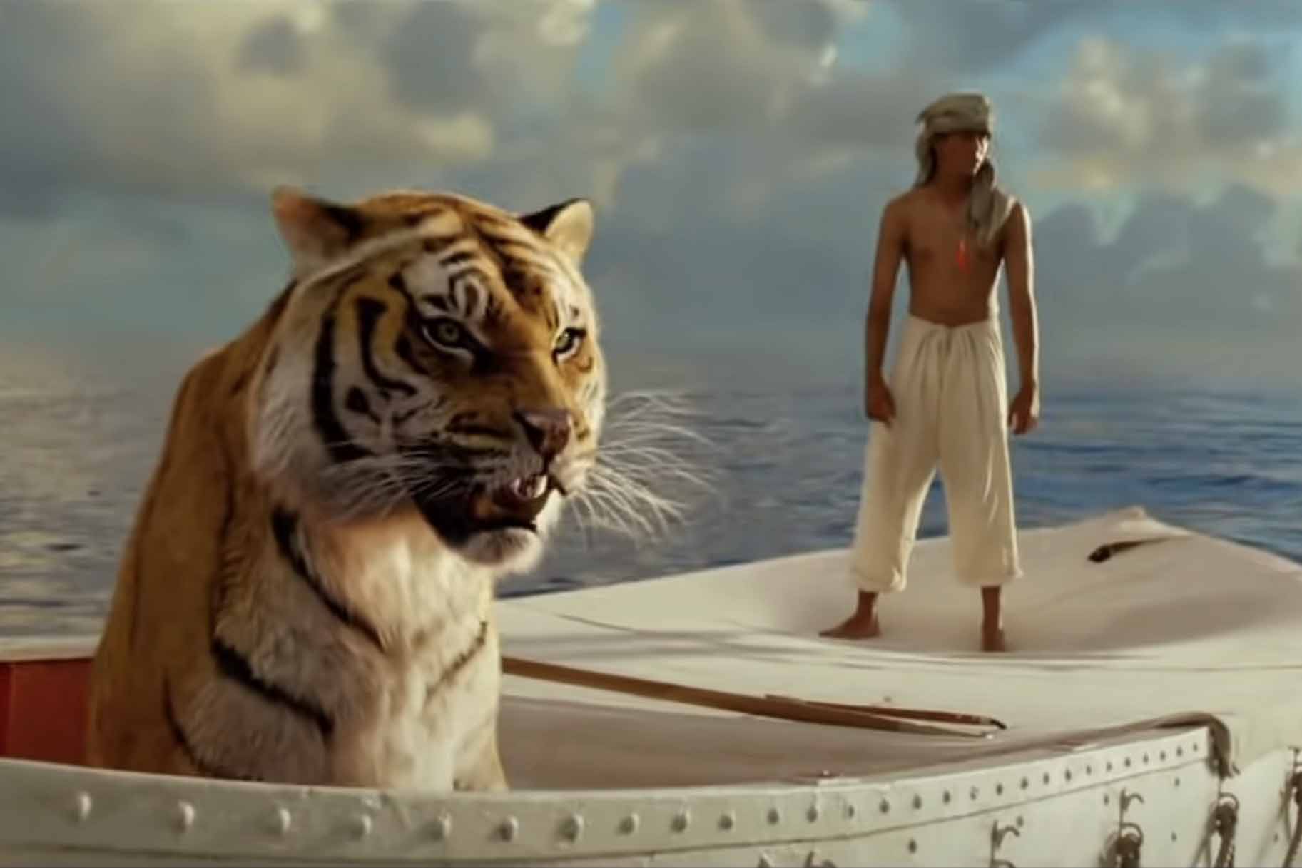 Pi Patel (Suraj Sharma) floats on a boat with a tiger in Life of Pi (2012).