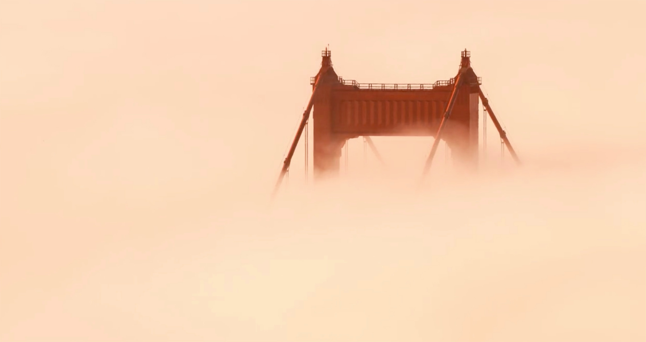 The Golden Gate Bridge almost lost in fog flowing in from the Pacific Ocean. Taken from the video “Adrift”. 