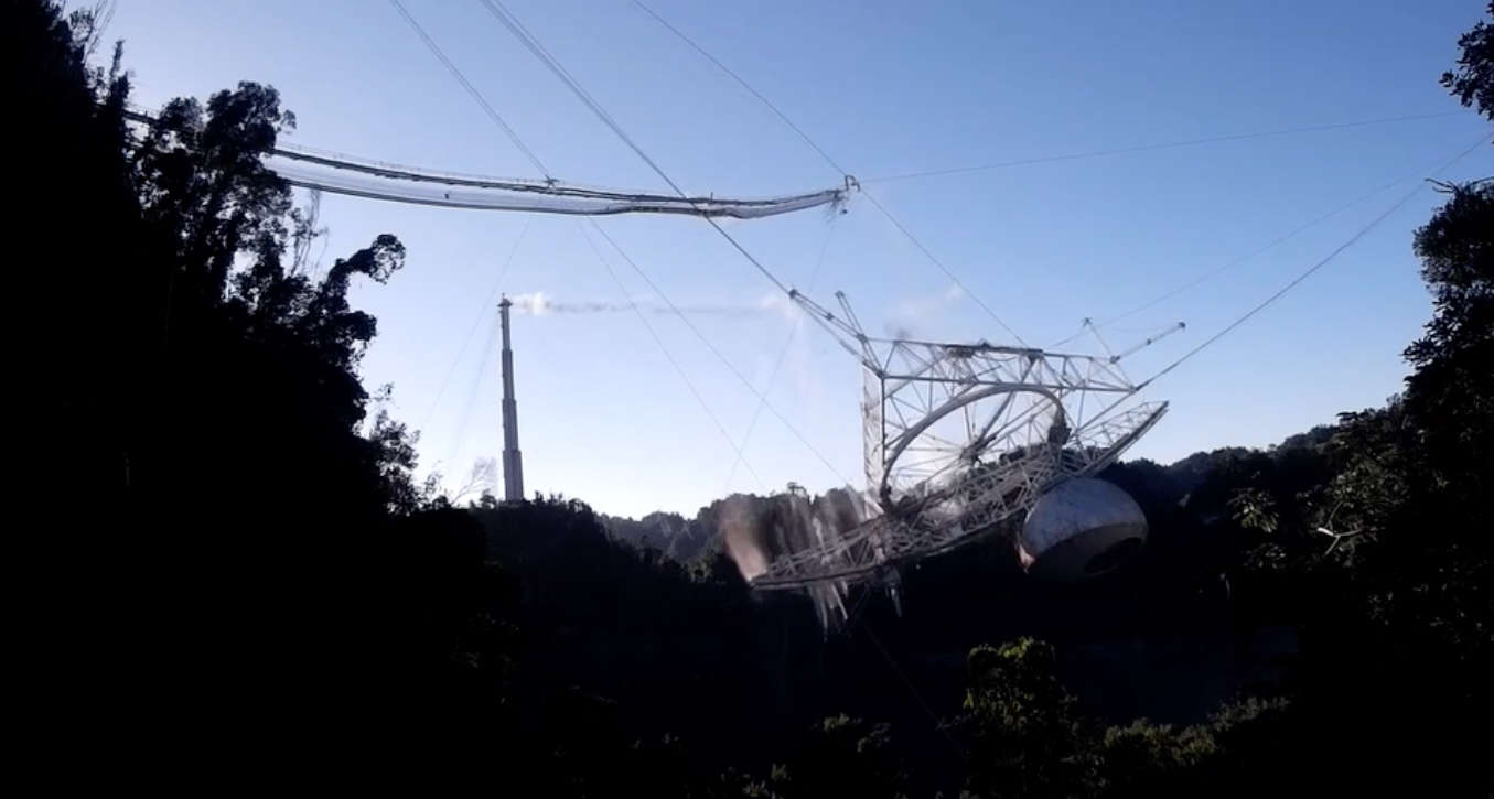 A still from the video of the Arecibo radio telescope collapse shows the massive 900-ton platform swinging down after supporting cables snapped. Credit: Courtesy of the Arecibo Observatory, a U.S. National Science Foundation facility