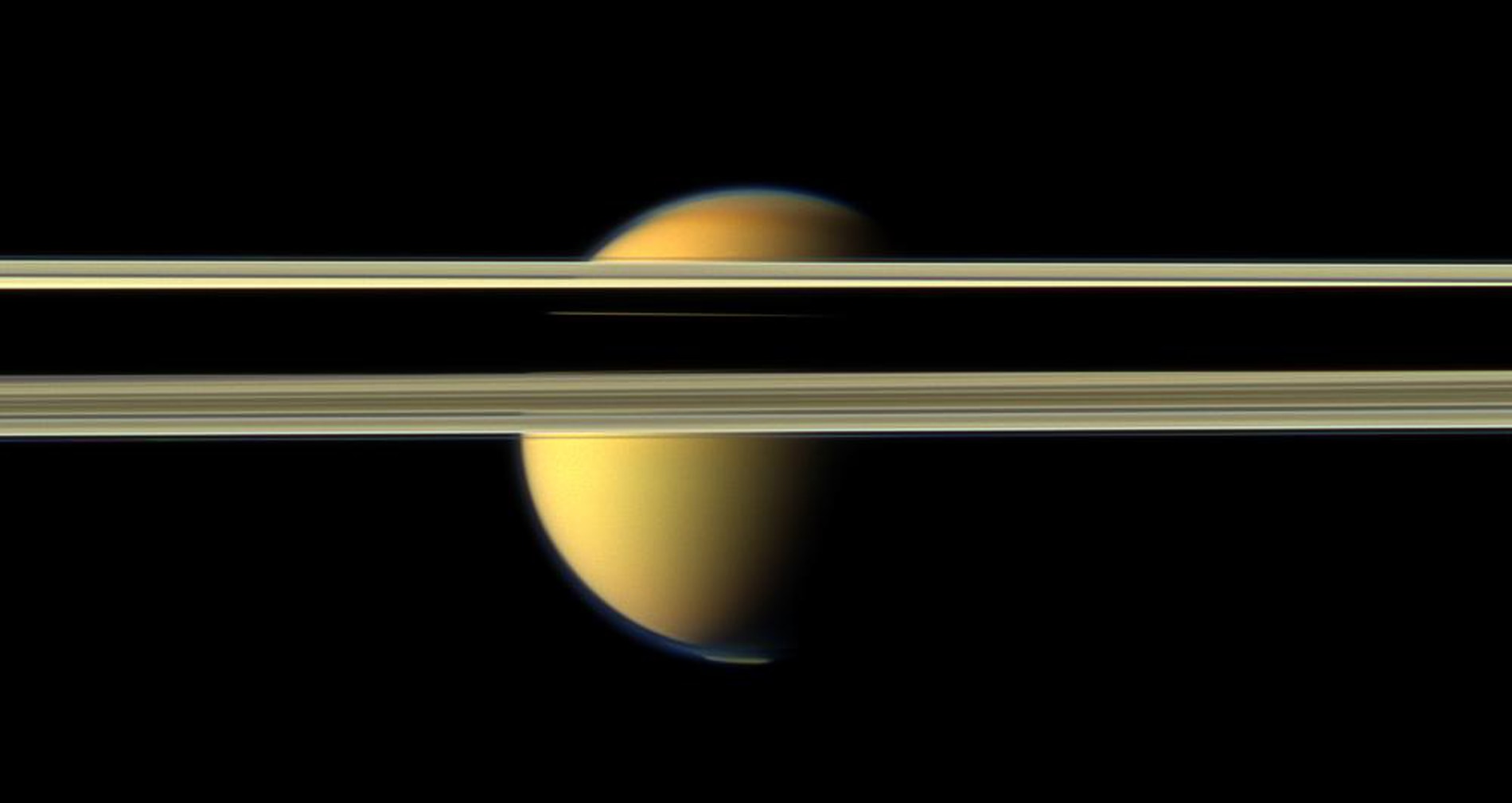 Titan tries to hide behind Saturn’s rings in this image from 2012. Note the visible bluish haze layer in Titan’s upper atmosphere. Credit: NASA/JPL-Caltech/SSI