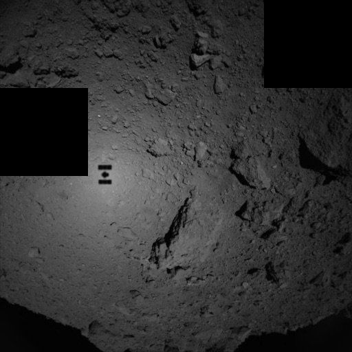 This view of the asteroid Ryugu was taken when Hayabusa-2 was only 80 meters above the surface! The shadow of the spacecraft can be seen too. Credit: JAXA