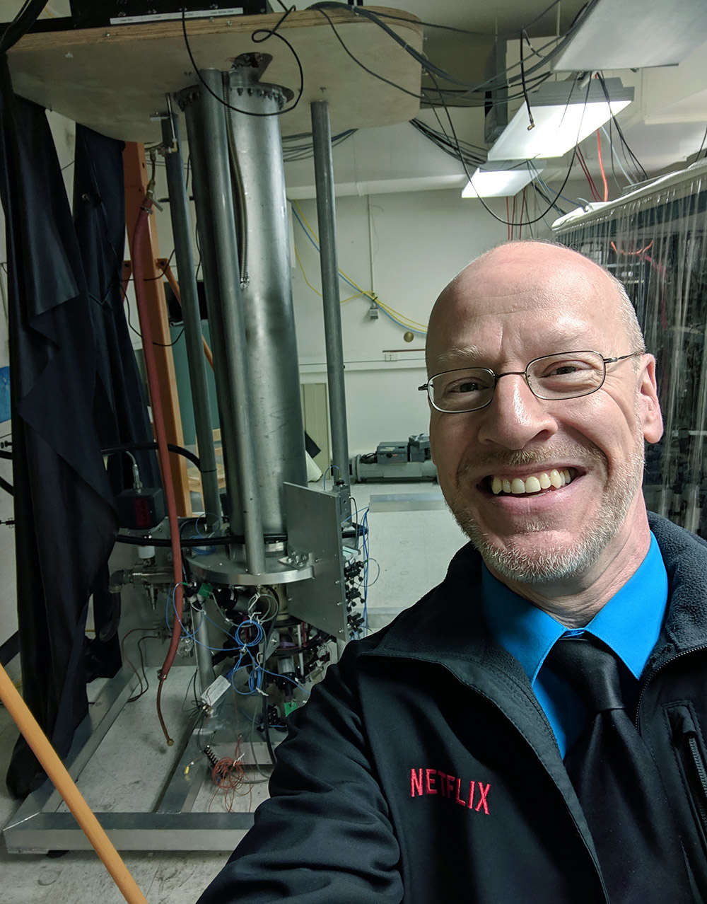 Your host, while visiting the National Institute of Standards and Technology in Boulder, Colorado (after giving a talk, explaining the tie), standing in front of the F-1 atomic clock which keeps time to an accuracy of 1 second every 100 million years.
