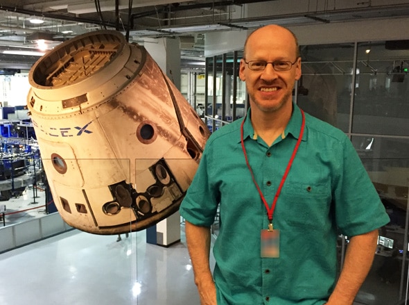 Phil Plait in front of the very first Dragon capsule that went to space. Note the scorch marks. Credit: Phil Plait / SpaceX