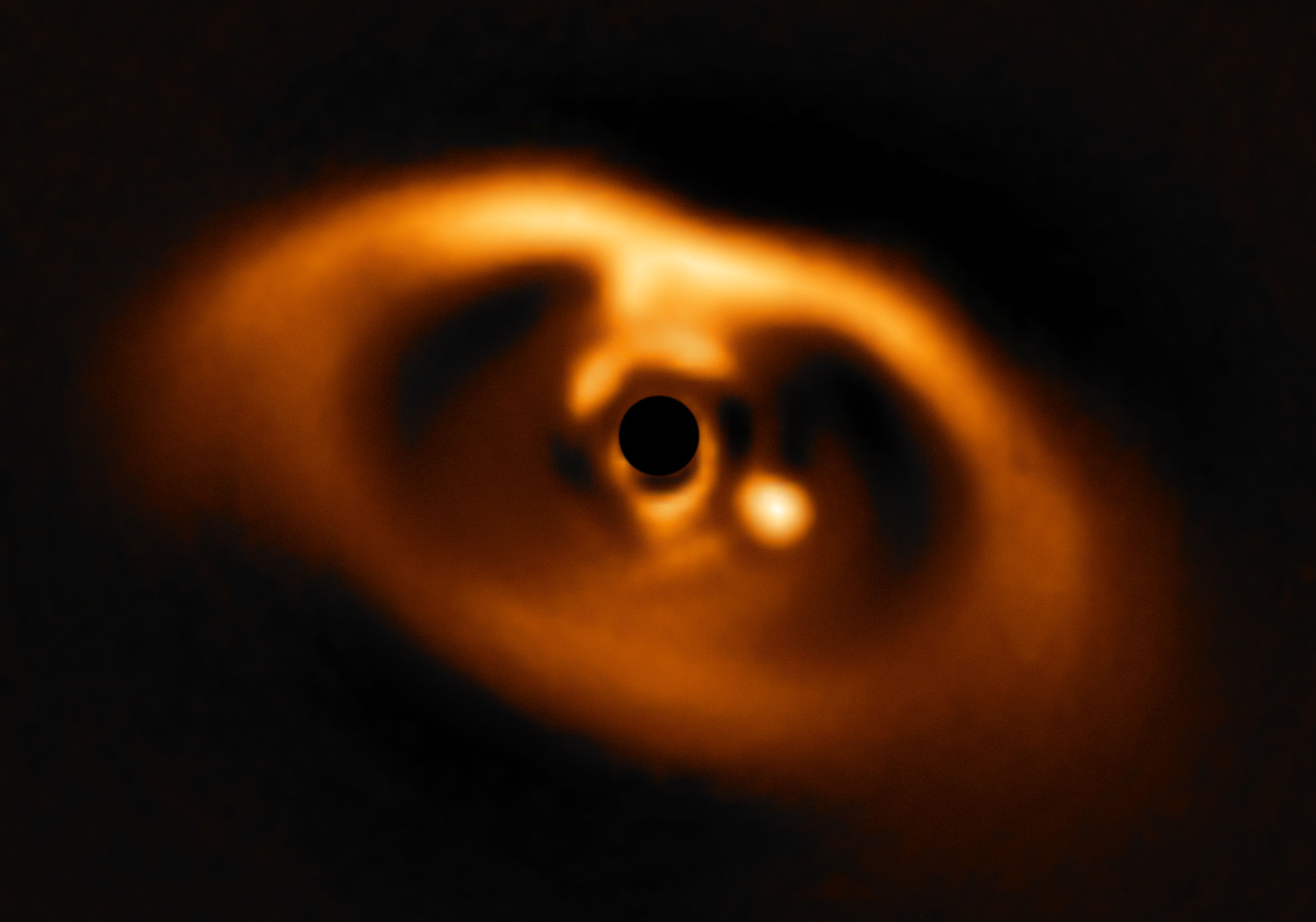 Image of the disk around the star PDS 70 (masked out to reduce brightness), showing the planet PDS 70b (bright spot to lower right). Credit: ESO/A. Müller et al.