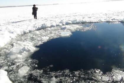 A hole in the frozen surface Lake Chebarkul made by the impact of a half-ton chunk of the Chelyabinsk meteorite on Feb. 15, 2013. We now have video of this event. Credit: ITAR-TASS Itar-Tass Photos/Newscom
