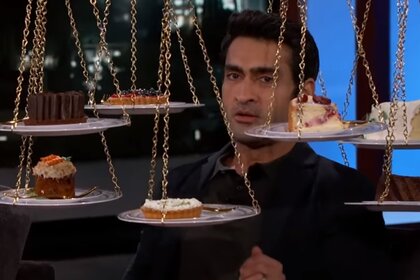Kumail Nanjiani surrounded by cakes