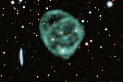 ORC1 in radio waves (green) superposed on visible light data from the Dark Energy Survey. The galaxy in the center can be seen as a yellowish dot.
