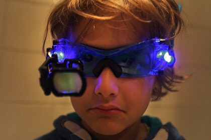 A boy looking with night vision goggles